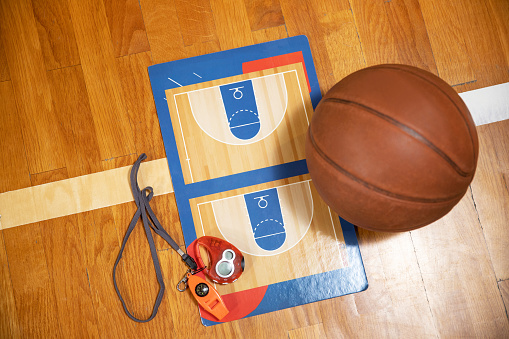 Details necessary for basketball training. Ball, coaching board, stopwatch and sports whistle.