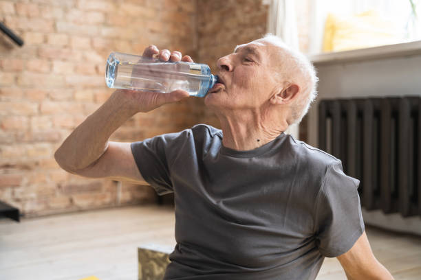 istock Active elderly man drinking water after fitness workout at home 1320141784