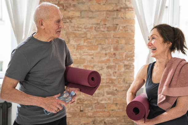 istock Two cheerful and active old people with exercising mats ready for workout 1320142513