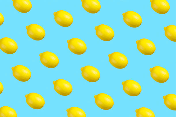 istock Colorful repetitive pattern made of isolated lemons on bright aqua blue background 1320142522