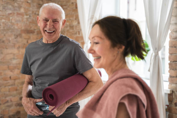 istock Two cheerful and active old people with exercising mats ready for workout 1320142544