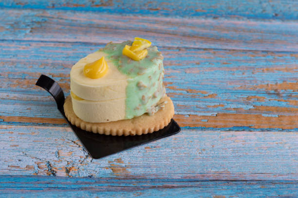 Delicious lemon and white chocolate crunchy dessert with a cookie on a background of old wood.