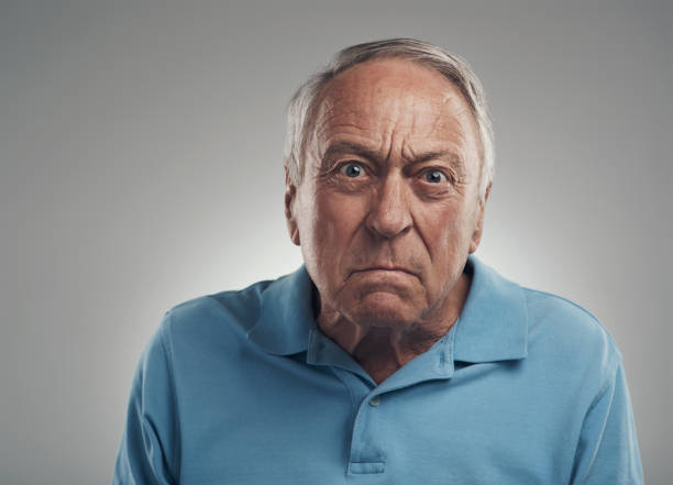istock Shot of an old man looking angrily at the camera in a studio against a grey background 1320142947
