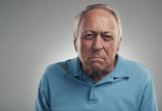 Shot of an old man looking angrily at the camera in a studio against a grey background You make me so angry grumpy stock pictures, royalty-free photos & images