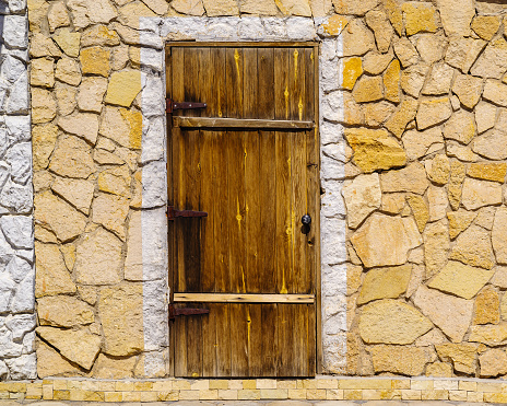 Wooden door in a stone wall. The picture was taken in Russia, in the city of Orenburg