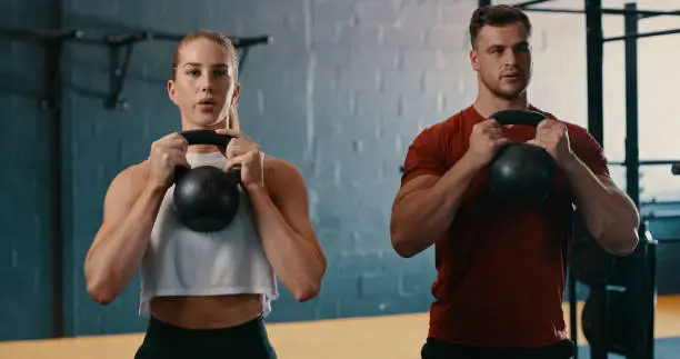 Photo of Shot of two people working out with kettlebells at the gym