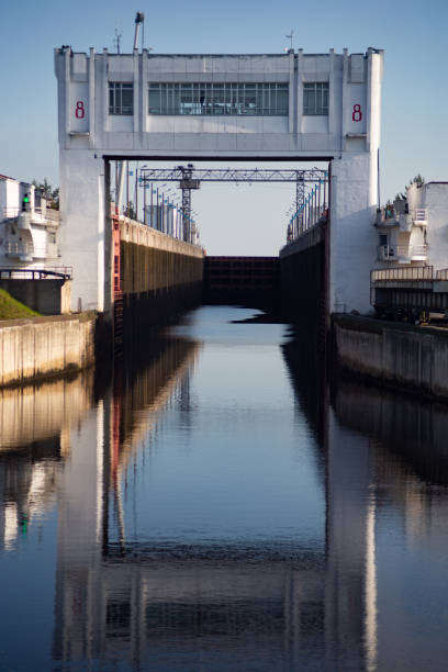 Locks for vessels on the Moscow canal. Organization of vessel traffic on the river. The lock building is reflected in the water.