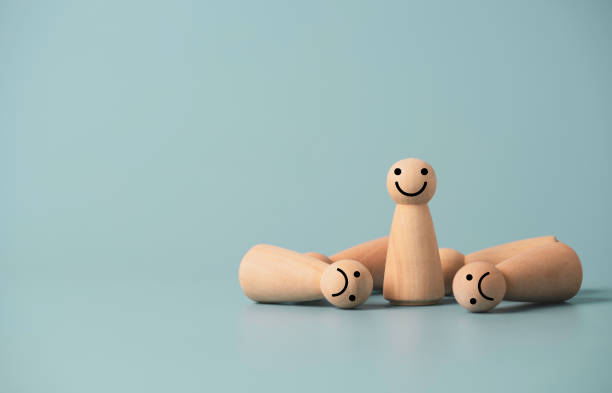 istock Smiley wooden figure standing among sadness falling , winner with competition concept. 1320144227