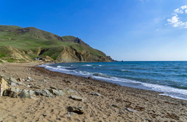 una spiaggia di sabbia vuota ai piedi di capo meganom. crimea. - out of season foto e immagini stock