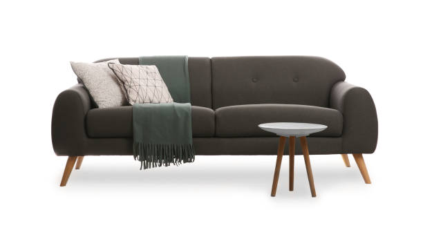 istock Comfortable grey sofa with cushions, blanket and table on white background. Furniture for living room interior 1320146530