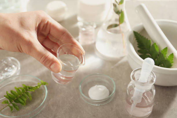 istock Scientist making cosmetic product at grey table, closeup 1320146702