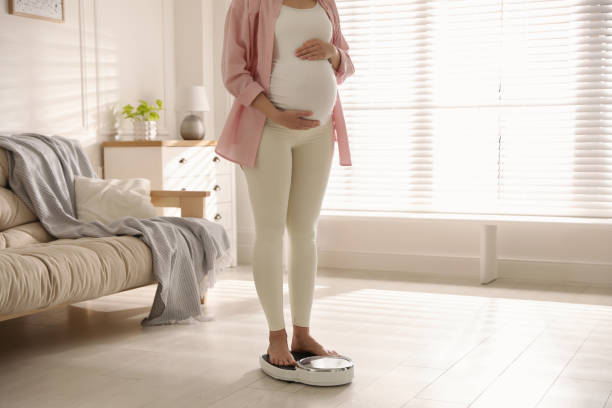mujer embarazada de pie en escalas en casa, primer plano - anticipation built structure indoors image technique fotografías e imágenes de stock