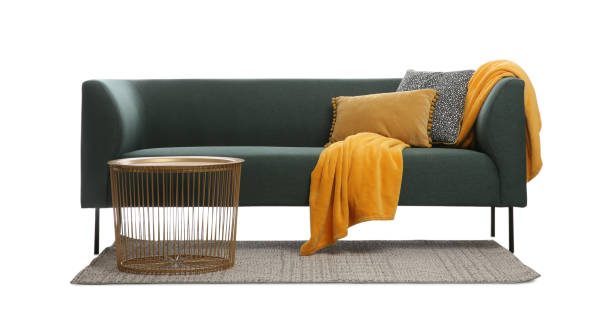 舒適的綠色沙發，配有靠墊、毯子和白色背景的桌子。客廳內部傢俱 - 毛氈 圖片 個照片及圖片檔