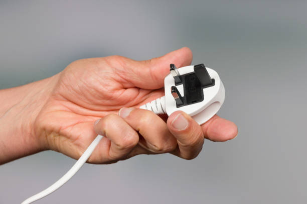 a hand with an electrical plug hand with a plug three pin plug stock pictures, royalty-free photos & images