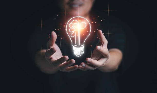 istock Man hand holding hanging glowing drawing light bulb with orange rays , creative thinking idea and innovation concept. 1320147737