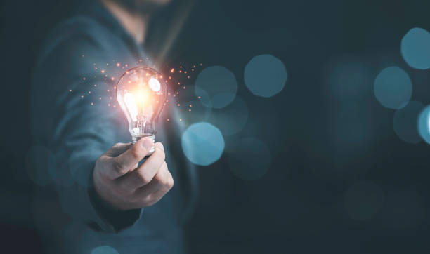 istock Businessman holding glowing lightbulb with light ray for creative thinking ideas and innovation concept. 1320148416