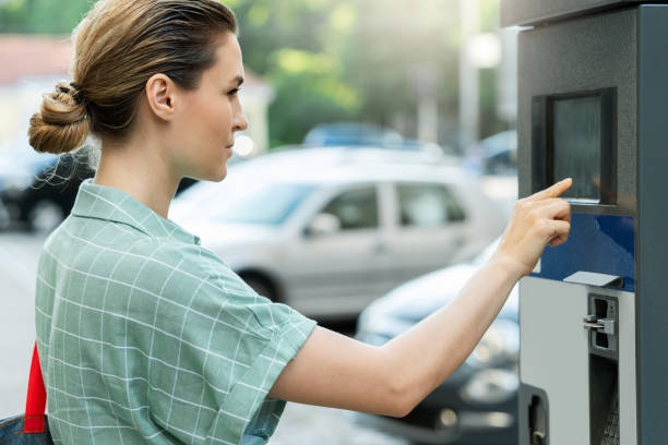 istock Attractive woman paying in the parking meter machine 1320149933