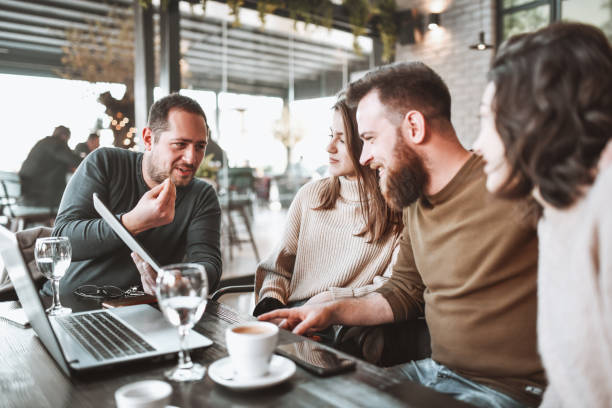 istock Friends Looking At Different Pictures On Digital Tablet And Laptop While Enjoying Coffee Time 1320150078