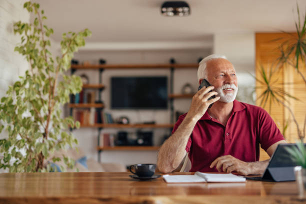 istock Mature man, taking a phone call, at home office. 1320151901