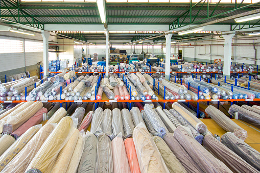 Photo of colourful rolls of fabrics, at a fabric warehouse