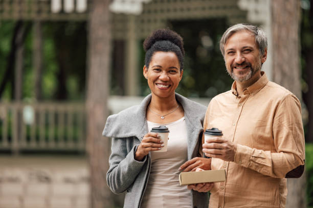 istock Mature couple, walking outside, drinking coffee, looking at camera. 1320153760