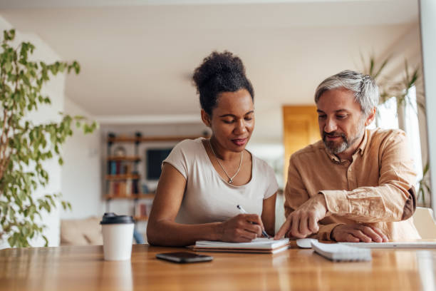 istock African woman writing in a notebook, with her partners support. 1320153779