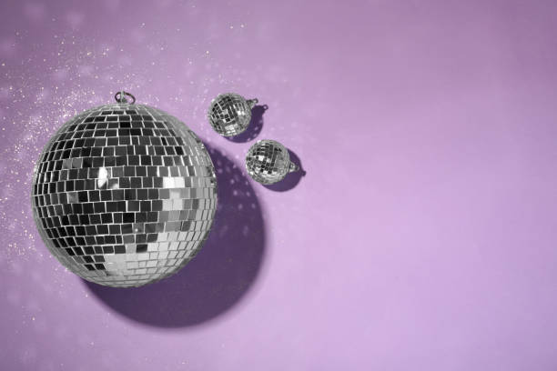 istock Bright shiny disco balls on violet background, flat lay. Space for text 1320153874