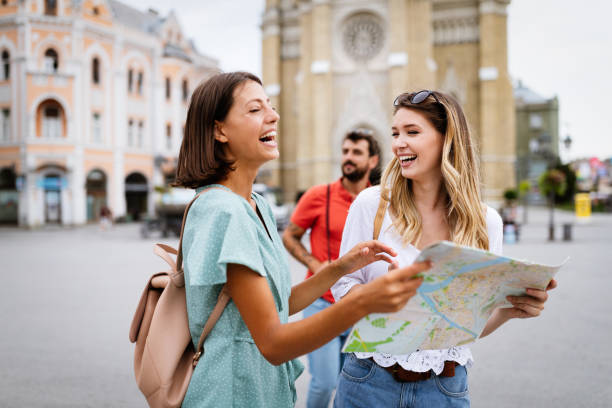 istock Happy traveling tourists sightseeing with map in hand 1320154176