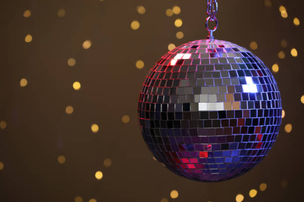 istock Shiny disco ball against blurred lights on brown background, space for text 1320154192