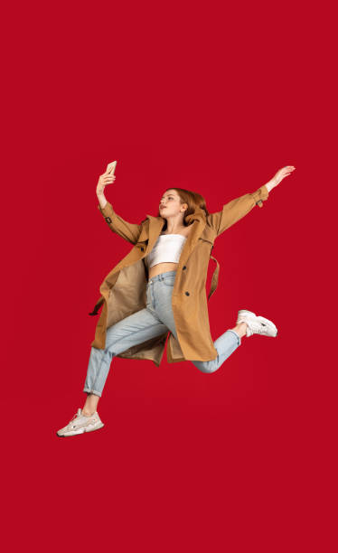 istock Young happy girl jumping isolated over red studio background with copyspace for ad. Concept of beauty, fashion. 1320156627