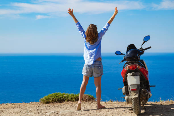 istock Woman with scooter looking at the distant sea horizon. 1320157732