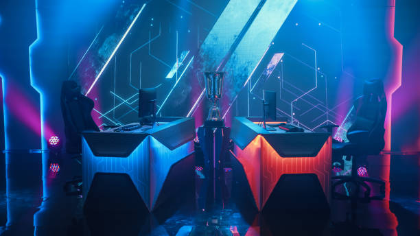 istock Two Person Empty Computer Gaming eSports Championship Arena with Winner Trophy Standing on a Stage. Stylish Online Live Streaming Tournament with Big Screens Showing Graphics and Neon Stage 1320158080