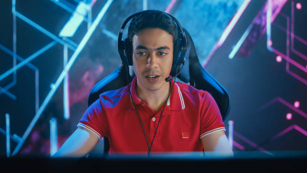 gamer profissional de esports jogando em jogos de vídeo de computador. gráficos elegantes de fundo. campeonato online / evento de streaming de torneios. vista frontal do retrato - arab style audio - fotografias e filmes do acervo