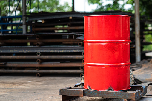 A red chemical or lubricant oil barrel container is placed at the industrial workshop area. Industrial equipment object photo.
