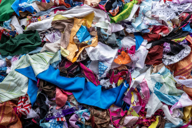 The background of the rag pieces of various colors are stacked together in a scattered mess. The background of many rag pieces of colorful fabrics which have been left from the sewing and repairing of the clothes by an elderly Thai woman for a long time. rubbish heap stock pictures, royalty-free photos & images