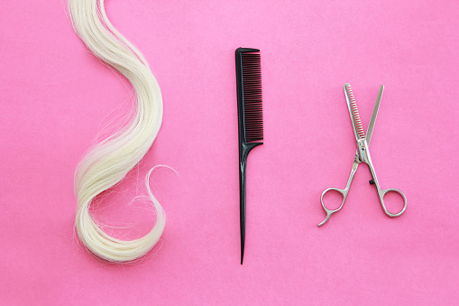 a disheveled lock of hair and a hairdressing clipper