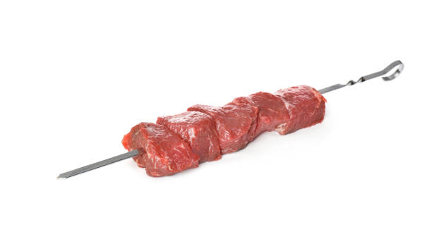 istock Metal skewer with raw meat on white background 1320161046