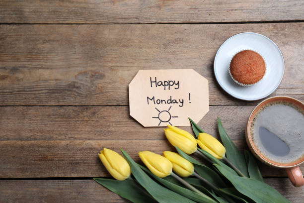 istock Happy Monday message, aromatic coffee, cupcake and tulips on wooden table, flat lay 1320161149