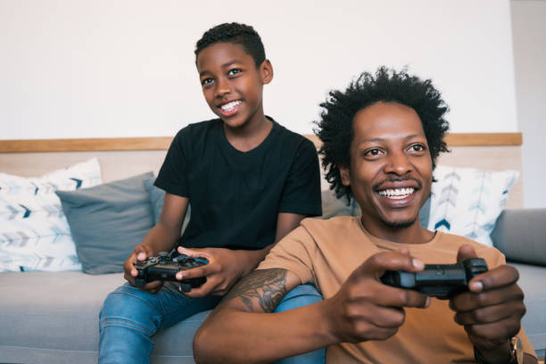 istock Father and son playing video games together at home. 1320163644