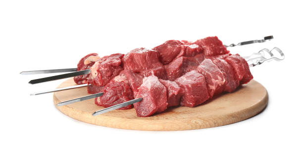istock Metal skewers with raw meat on white background 1320163754