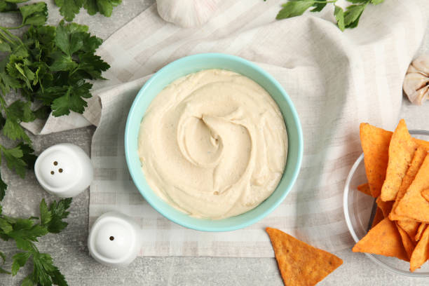 istock Delicious hummus, nachos and parsley on grey table, flat lay 1320163755