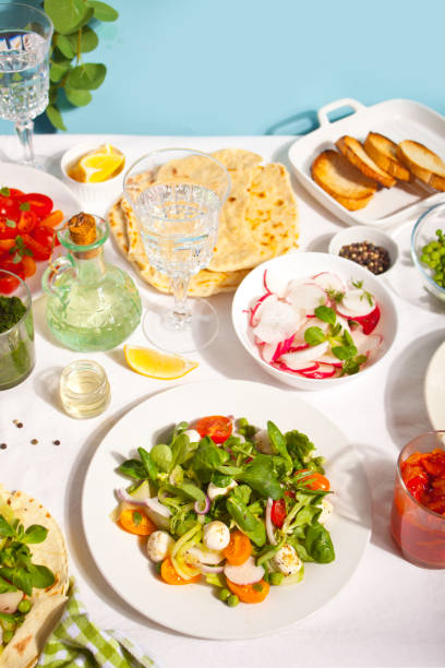 istock salad of fresh cherry tomatoes, mozzarella, basil and other greens on the dinner table with pita flat bread 1320165339