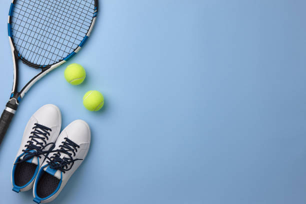 raqueta de tenis y zapatos sobre fondo azul - deporte de raqueta fotografías e imágenes de stock