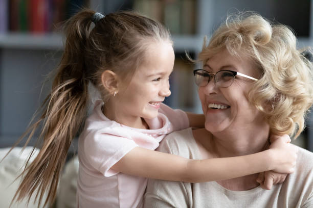 menina afetuosa abraçando sorridente avó aposentada mais velha. - grandmother and grandaughter - fotografias e filmes do acervo