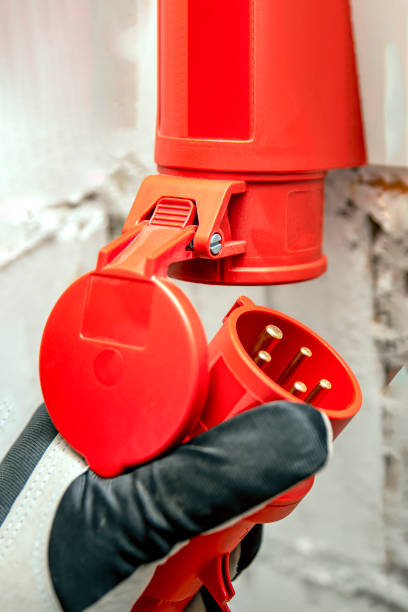 costo dell'elettricità, prezzo dell'elettricità, presa industriale ad alta tensione. spina ad alta tensione in mano. collegamento di un'alta tensione a 380 volt, spina a tre fasi a una presa. - electric plug outlet human hand electricity foto e immagini stock