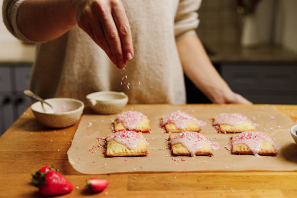 istock Woman garnishing pop tarts with sugar sprinkles 1320170846
