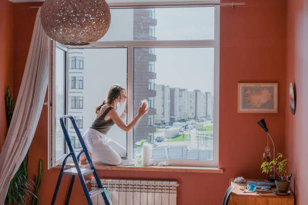 Woman painting a wall in her home during lockdown, covid-19 crisis.