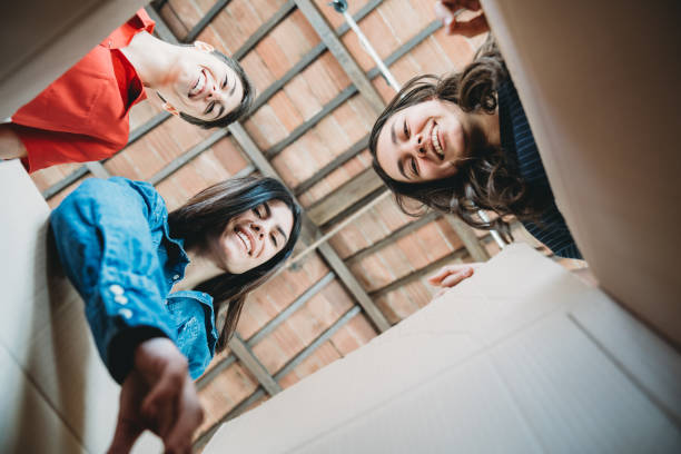 istock Three women are taking something from a cardboard box - View from inside the box 1320176682