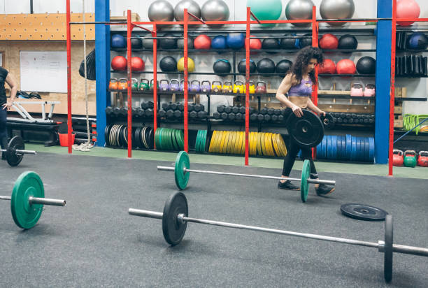 istock Woman picking up weightlifting discs 1320177930
