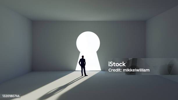 Man Stands Before A Key Decision And Faces A Wall With Giant Key Hole Stock Photo - Download Image Now